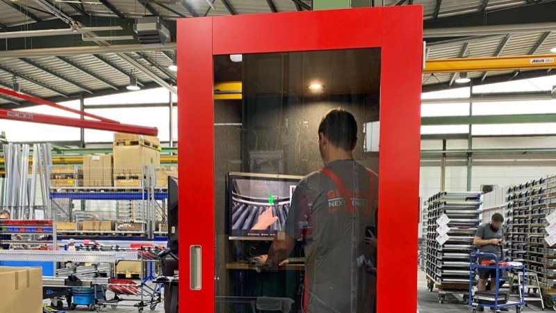 Ein Arbeiter erhält AR Video Support in einer Telefonkabine in der Werkshalle.