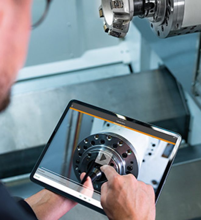 Ein Techniker verwendet eine visuelle Anleitung auf seinem Tablet, um eine Maschine zu bedienen.